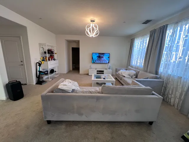 a living room with furniture a chandelier and a window