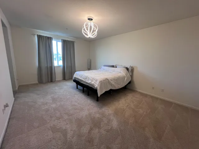 a spacious bedroom with a bed and a window