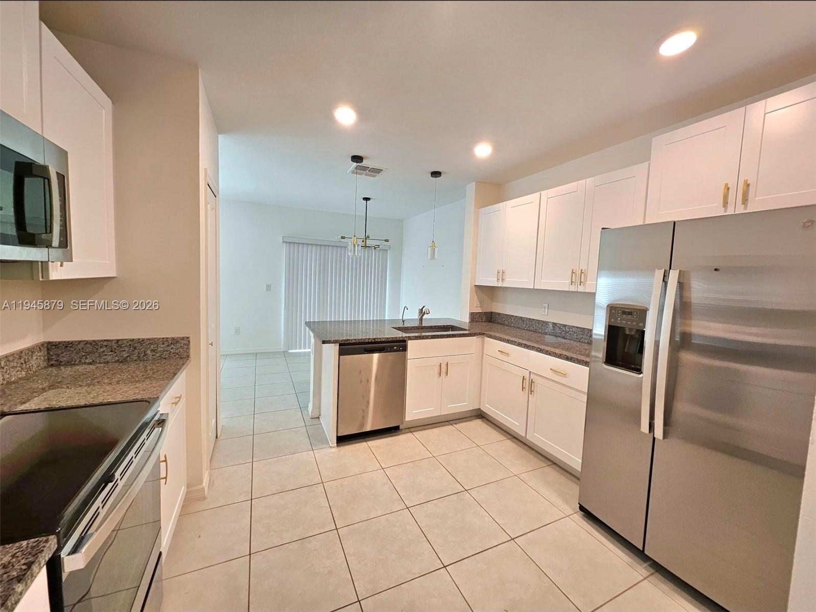 6346 Back Forty Loop, Unit 6346 Zephyrhills, FL 33541 - Photo 23 of 35 a kitchen with a sink a counter top space stainless steel appliances and cabinets