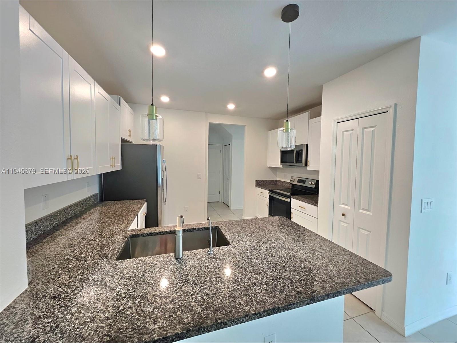 6346 Back Forty Loop, Unit 6346 Zephyrhills, FL 33541 - Photo 24 of 35 a kitchen with stainless steel appliances granite countertop a sink a stove and a refrigerator