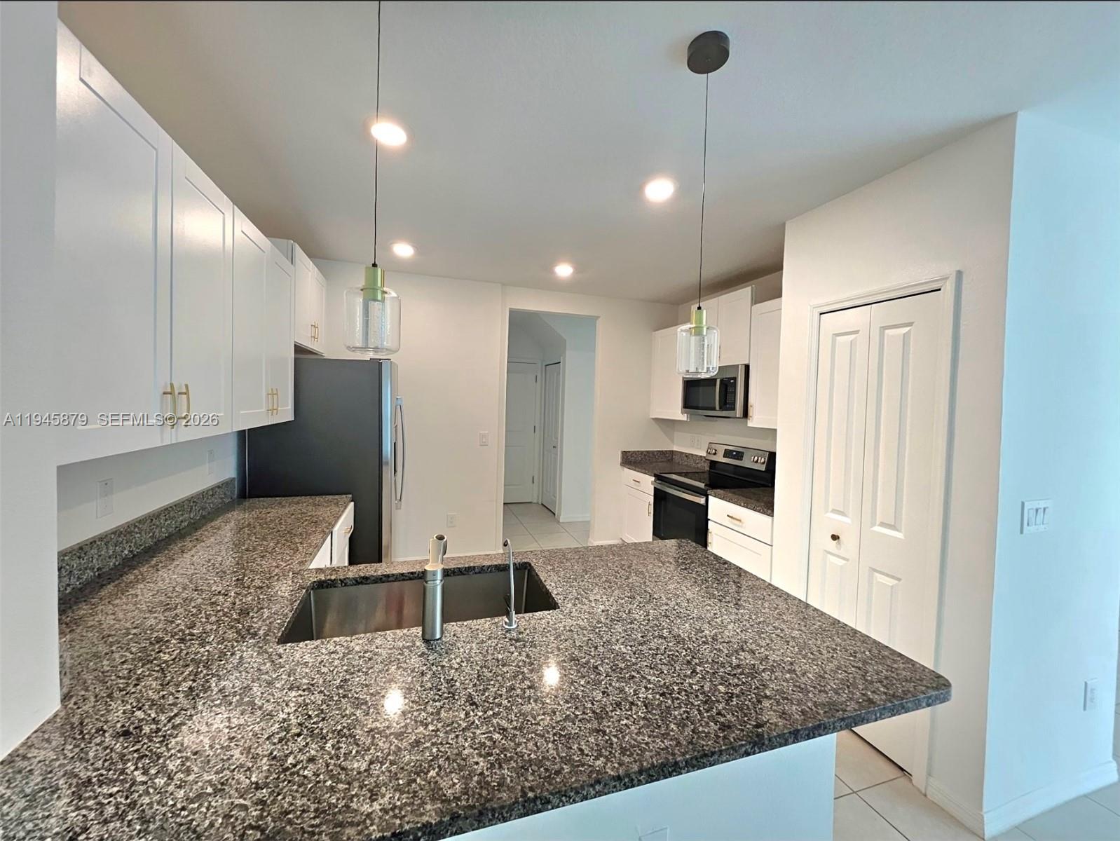 6346 Back Forty Loop, Unit 6346 Zephyrhills, FL 33541 - Photo 25 of 35 a kitchen with a refrigerator a sink and cabinets