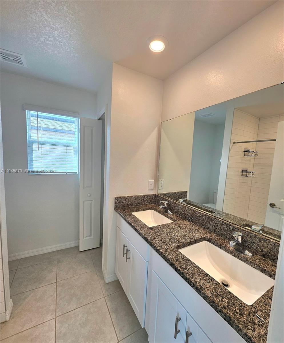 6346 Back Forty Loop, Unit 6346 Zephyrhills, FL 33541 - Photo 10 of 35 a bathroom with a granite countertop sink and a mirror