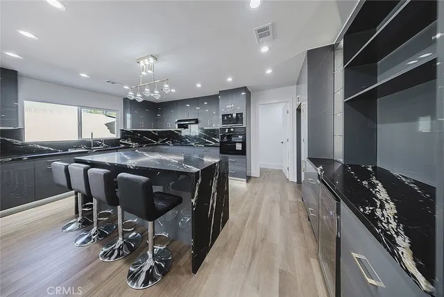 an empty room with wooden floor a ceiling fan and windows