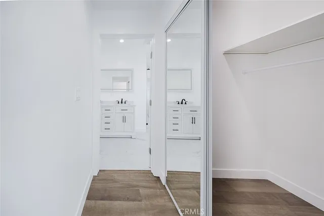 a view of an empty room with kitchen and a window