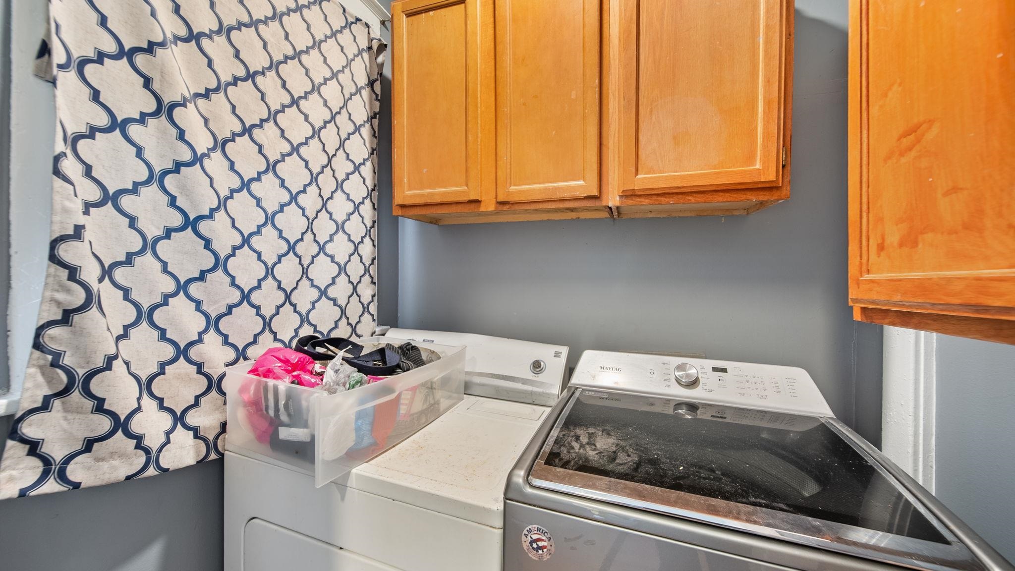 659 Decatur Street Memphis, TN 38107 - Photo 13 of 24 Laundry area featuring wood cabinetry, painted walls, and window with patterned coverings