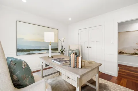 a view of a bedroom with wooden floor and furniture
