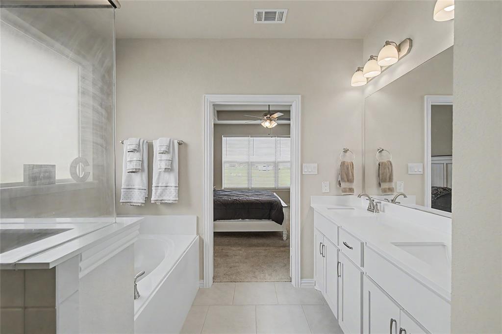 185 Chester Road Springtown, TX 76082 - Photo 4 of 40 Bathroom featuring a double vanity with white cabinetry, light countertops, and an integrated rectangular sink