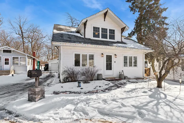 a front view of a house with a yard covered in snow