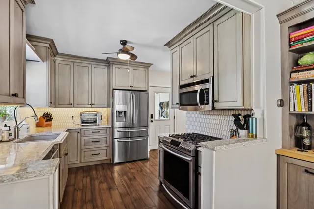 a kitchen with stainless steel appliances a stove sink and refrigerator