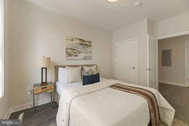 a bedroom with a bed and a painting on the wall