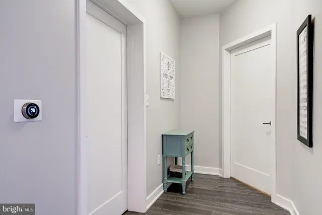 a view of a hallway with wooden floor and closet