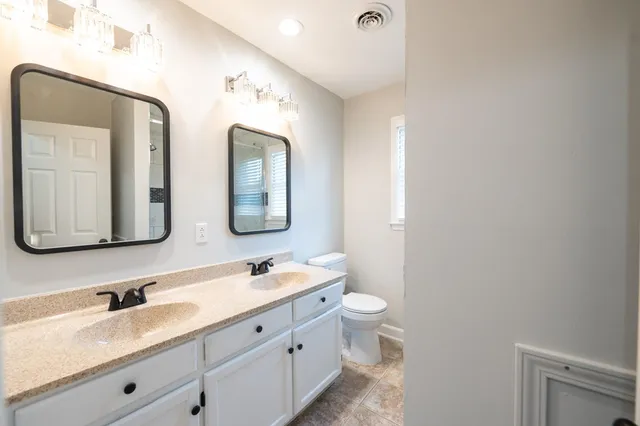 a bathroom with double vanity sinks and a mirror