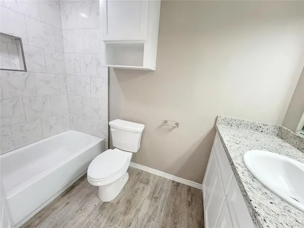 a white toilet sitting next to a bathroom sink and a bathtub