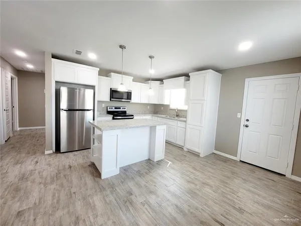 a kitchen with stainless steel appliances a refrigerator sink and microwave