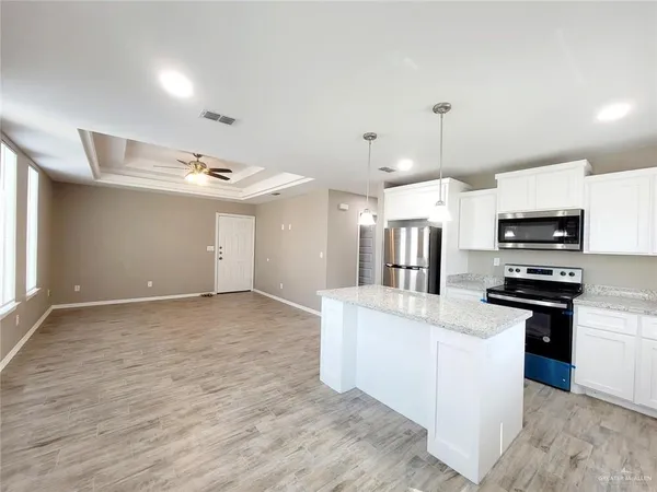 a kitchen with stainless steel appliances kitchen island granite countertop a stove and a sink