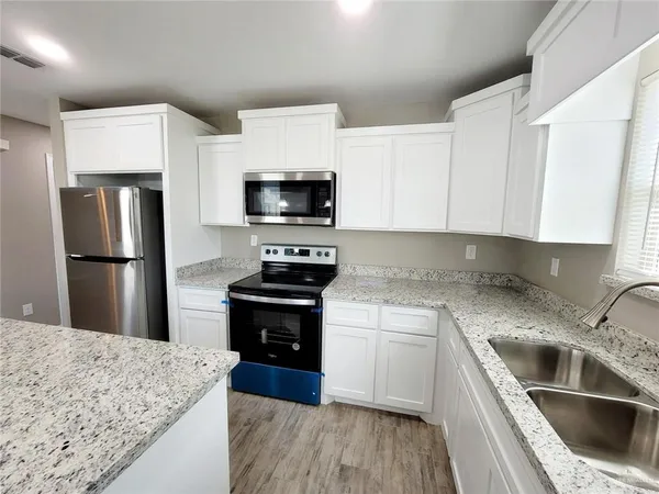 a kitchen with a sink stove and refrigerator