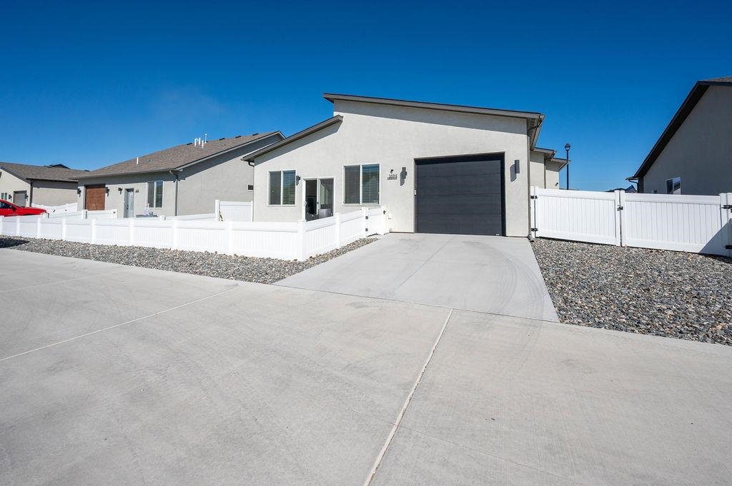 1694 Tungsten Way Fruita, CO 81521 - Photo 3 of 22 a front view of a house with a yard and garage