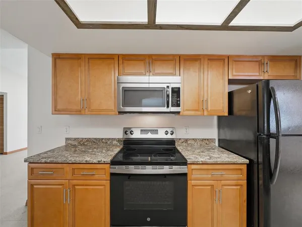 a kitchen with stainless steel appliances granite countertop a stove a sink and a refrigerator