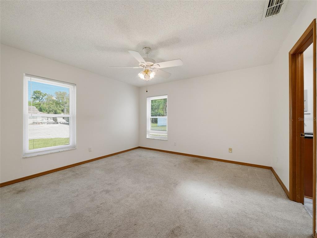 3303 Orange Tree Drive Edgewater, FL 32141 - Photo 17 of 33 an empty room with windows and fan