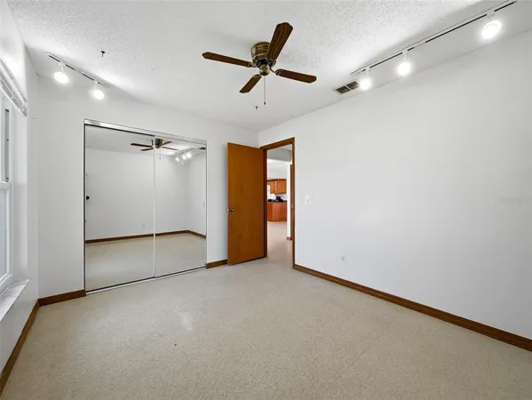 an empty room with a window and a ceiling fan