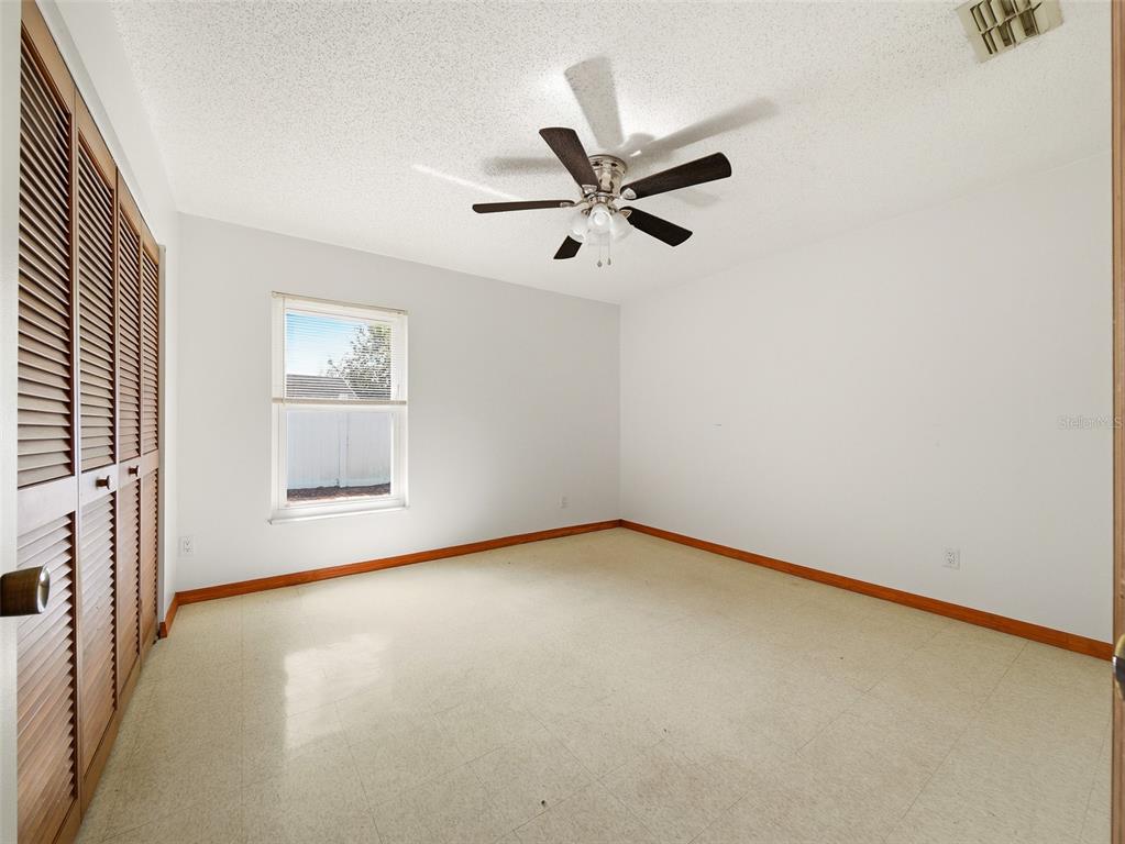 3303 Orange Tree Drive Edgewater, FL 32141 - Photo 24 of 33 an empty room with a window and a ceiling fan