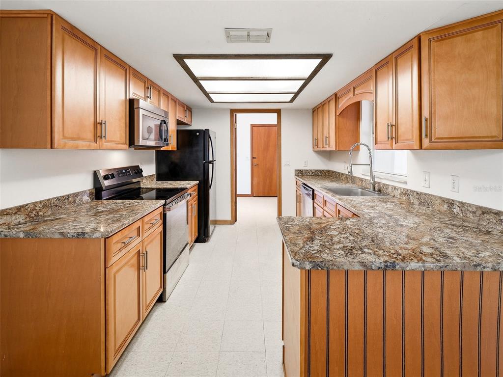 3303 Orange Tree Drive Edgewater, FL 32141 - Photo 6 of 33 a kitchen with stainless steel appliances granite countertop a stove a sink and a microwave