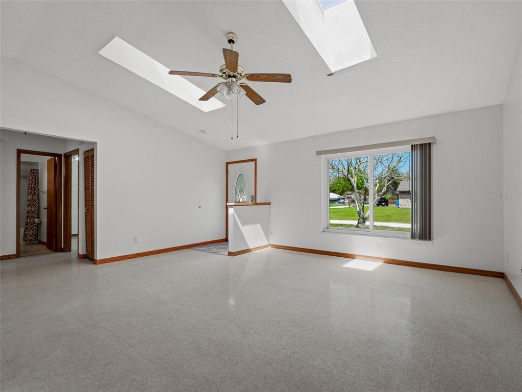 3303 Orange Tree Drive Edgewater, FL 32141 - Photo 8 of 33 an empty room with windows and ceiling fan