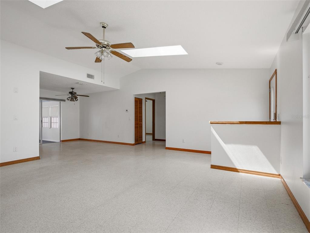3303 Orange Tree Drive Edgewater, FL 32141 - Photo 9 of 33 an empty room with ceiling fan and windows