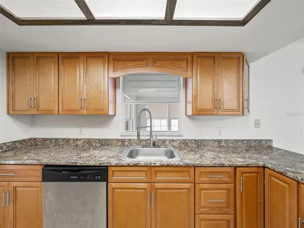 a kitchen with granite countertop cabinets stainless steel appliances a sink and wooden floor