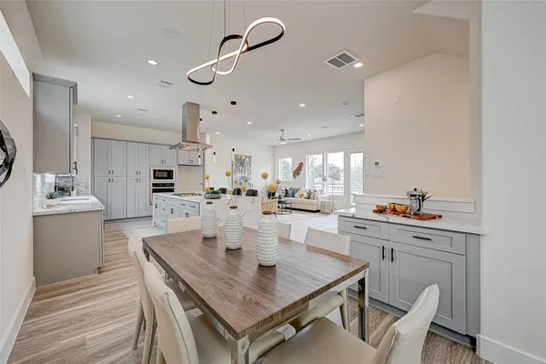 a room with stainless steel appliances kitchen island granite countertop a dining table chairs and view living room