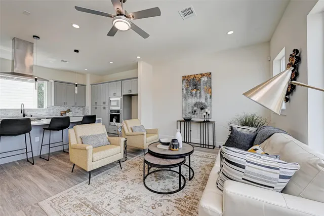 a living room with furniture a rug and white walls