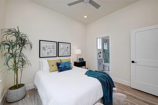 a bedroom with a large bed and a potted plant