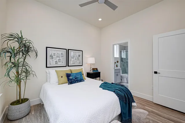 a bedroom with a large bed and a potted plant