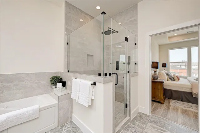 a bathroom with a tub shower and mirror