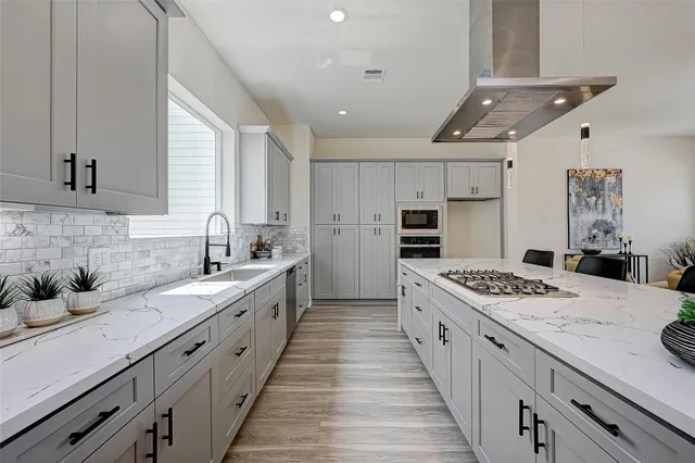 a kitchen with stainless steel appliances kitchen island granite countertop a sink stove and cabinets