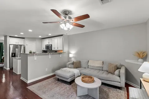 a living room with furniture and a view of kitchen
