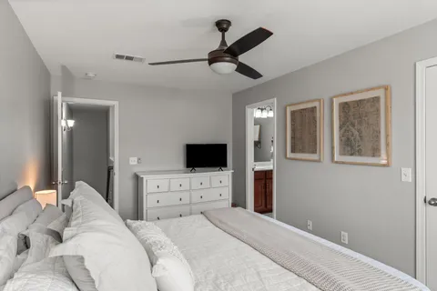 a bedroom with a bed and a flat tv screen on dresser