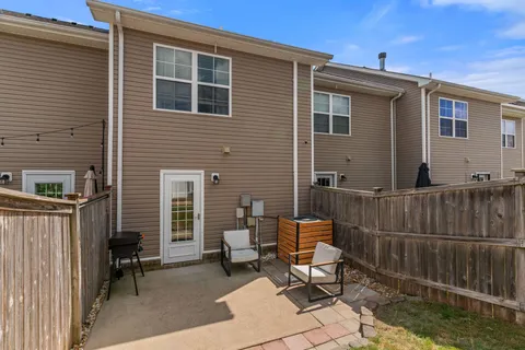 a view of a chair and tables in the back yard of the house