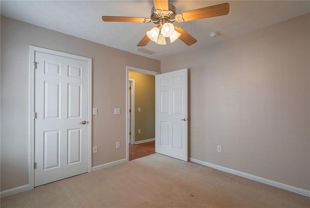 245 Memory Lane Winder, GA 30680 - Photo 36 of 62 an empty room with a chandelier fan and closet area
