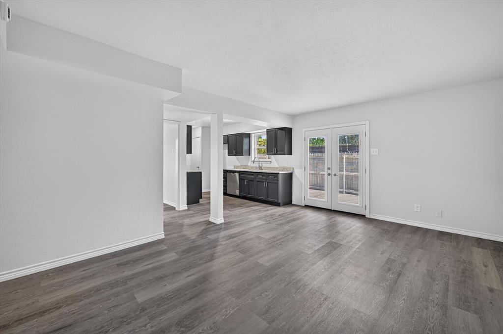 1801 East Grauwyler Road, Unit 101 Irving, TX 75061 - Photo 6 of 39 an empty room with wooden floor and windows