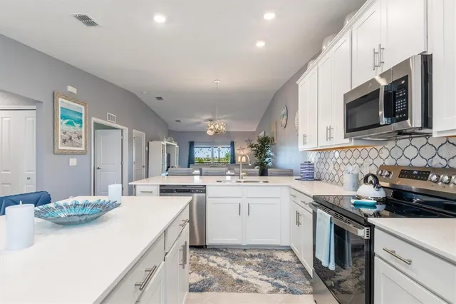 a kitchen with stainless steel appliances granite countertop a sink stove a microwave oven and a refrigerator