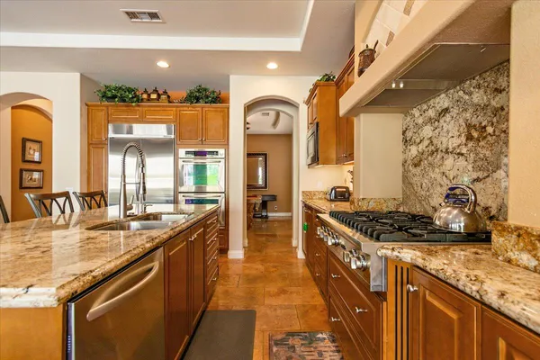a kitchen with stainless steel appliances granite countertop a stove and a sink