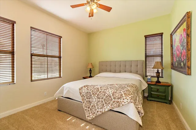 a bedroom with a bed painting on wall and a large window