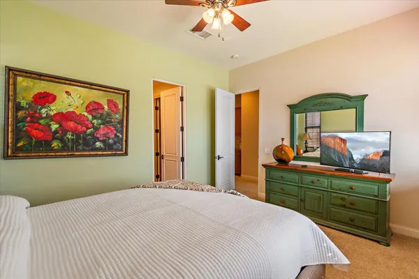 a bedroom with a bed and a painting on the wall