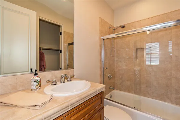 a bathroom with a granite countertop sink toilet and shower