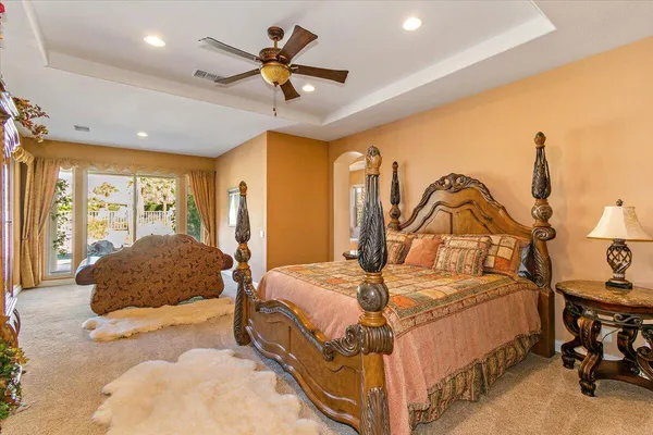 a bedroom with a bed a ceiling fan and a dresser