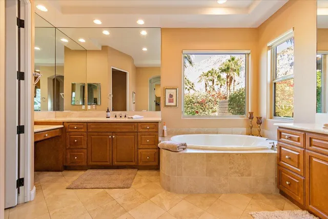 a spacious bathroom with a granite countertop tub sink shower and mirror