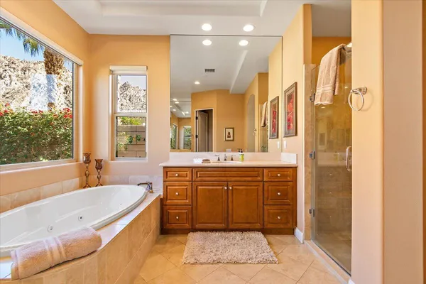 a spacious bathroom with a tub sink and mirror