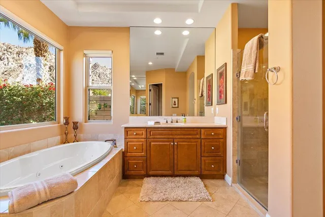 a spacious bathroom with a tub sink and mirror