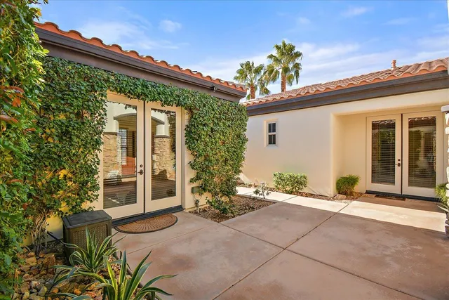front view of a house with a large window and potted plants